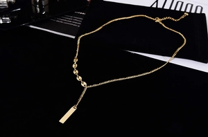 Detail of 18K gold-plated bar pendant on a minimalist stainless steel chain
