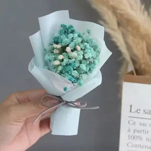 Close-up of a mini dried baby's breath bouquet in blue wrapping with a grey ribbon