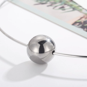 Detail shot of a polished silver hollow ball on a rigid punk stainless steel choker neckband