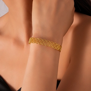 Detailed close-up of a gold hollow geometric flower cuff bracelet with lace texture