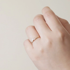 Close-up of elegant gold princess crown ring with marquise-cut zircons on a finger