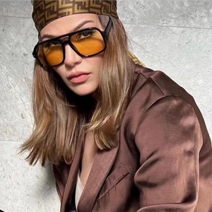 Retro Doppelsteg-Sonnenbrille mit schwarzem Rahmen und gelben Gläsern am Modell