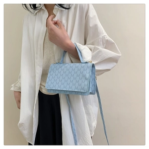 Detail of light blue crossbody bag with all-over M letter print and adjustable strap