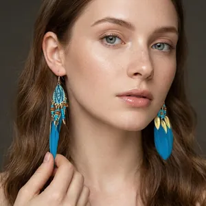Detail view of blue feather fringe earrings with gold leaves on a female model