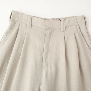 Women's beige sleeveless vest and pleated pants two-piece set waist detail view