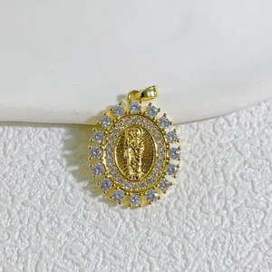 Macro shot of gold oval pendant with religious relief and sparkling cubic zirconia stones