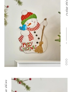 Detail of wooden snowman wall hanging with Merry Christmas text and festive pine decor