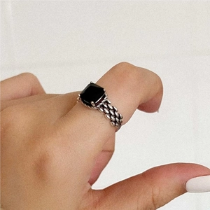 Close-up of vintage 925 silver woven ring featuring a square black gemstone on finger