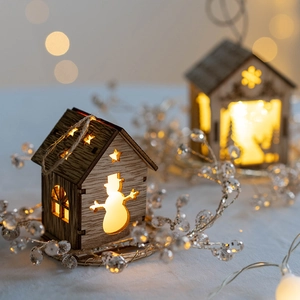 Lighted wooden Christmas house ornament with snowman and snowflake cutout patterns