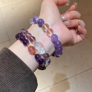 Wrist view of Amethyst and Rose Quartz beaded bracelets with golden charms and Pi Xiu detail