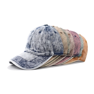 Close-up showing various colors of washed denim baseball caps with vintage distressed texture