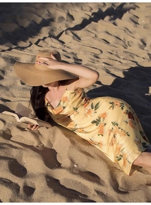Vue détaillée d'une robe d'été à fleurs jaunes dans un cadre de plage relaxant