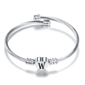 Dettaglio del bracciale rigido in acciaio inox con ciondolo a cuore e lettera W