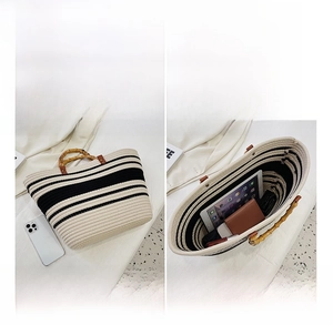 Detail of woven striped tote bag interior capacity with natural bamboo handles