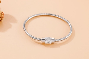 Vue détaillée du bracelet chaîne serpent argentée avec breloque cylindrique pavée de cristaux