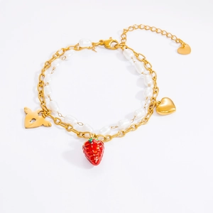 Detail of double-layer gold bracelet with strawberry pendant and white pearls