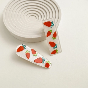 Close-up of glittery acrylic carrot hair clips in rectangular and teardrop shapes