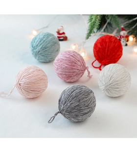 Detailed view of colorful wool felt Christmas balls with festive snowy background scenery