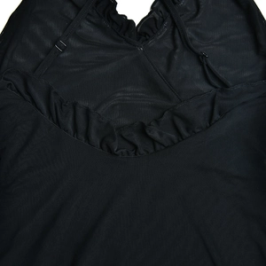 Detail view of black mesh fabric with ruffled lace neckline and adjustable strap buckles