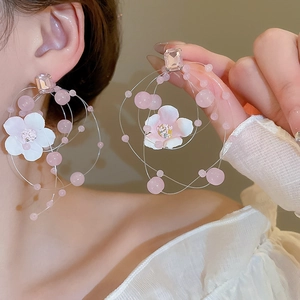 Detailed view of pink fabric flower earrings with crystal beads and layered alloy coils