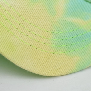 Tie-dye sun visor hat with vibrant yellow-green patterns and durable reinforced stitching