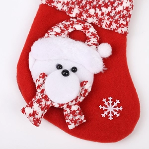 Red Christmas stocking with plush white bear and snowflake patterns on white background