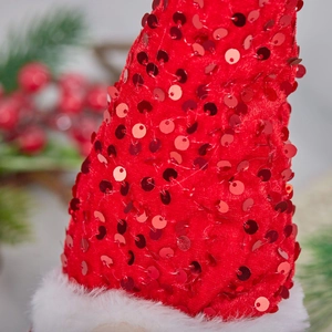 Gros plan d'un bonnet de Noël rouge à paillettes avec garniture en peluche blanche douce
