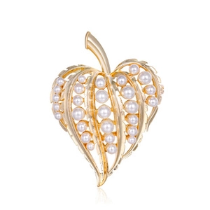 Detailed view of a golden leaf brooch adorned with small elegant white pearls