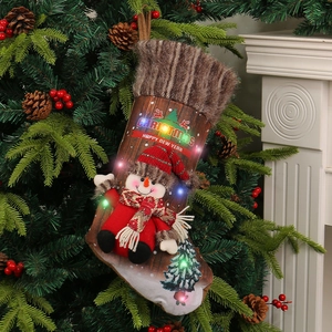 Christmas stocking with LED snowman figure hanging on tree by fireplace decor