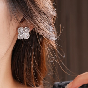 Gros plan d'une boucle d'oreille trèfle à quatre feuilles en argent et zircone