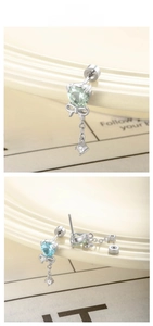 Macro shot of heart-shaped zircon and bow tassel drop earrings in light blue and green