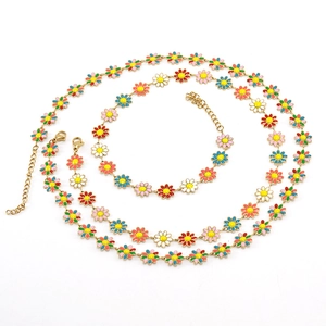 Bijoux en chaîne d'acier doré avec marguerites colorées en émail sur fond blanc