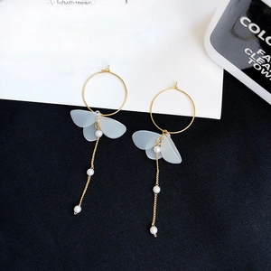 Detail view of long butterfly drop earrings with blue frosted wings and hanging pearls