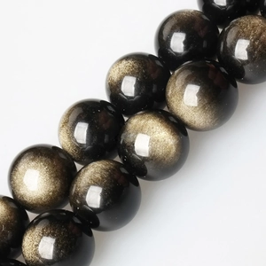 Macro shot of natural golden obsidian round beads showing golden sheen on white background