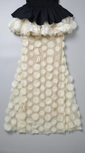 Detail of white 3D floral appliqués on sheer mesh skirt of an elegant evening dress