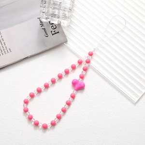 Pink and white heart beaded phone charm strap on a textured minimalist background