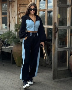 Dettaglio della felpa con patchwork in denim e joggers a vita alta su una modella