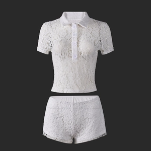 Detail of white floral lace polo top and matching shorts in high-quality fabric texture