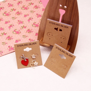 Detail view of heart and flower earrings on a kraft paper sterling silver card