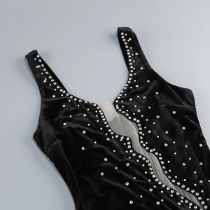 Detail of black velvet evening dress with deep V-neckline and sparkling rhinestone trim