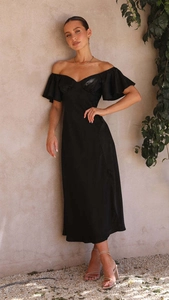 Détail de la robe noire élégante à épaules dénudées avec manches à volants et fini satiné