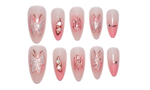 Detailed macro view of almond gradient press-on nails with butterflies and rhinestones