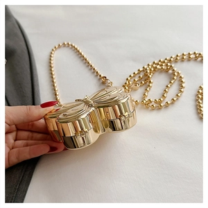 Detailed view of the golden metal butterfly clutch bag with a pearl chain strap