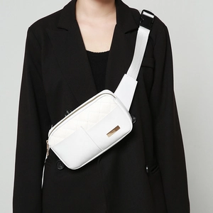 White quilted waist bag with gold zippers and adjustable strap worn by a female model