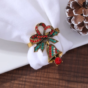 Macro view of golden Christmas napkin ring with ribbon bell and colorful rhinestones