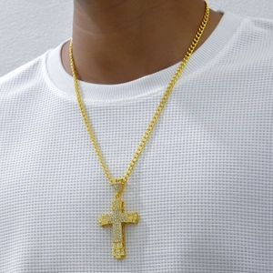 Hip hop style gold cross pendant necklace with diamonds on a model for men
