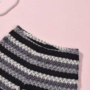 Close-up of knit shorts waistband featuring black and white wave pattern texture
