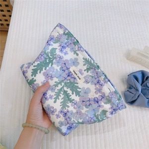 Close-up of floral cotton makeup bag with simple wish label and soft lavender patterns