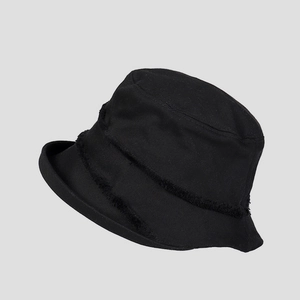 Detail of black cotton bucket hat showing frayed edges and textured canvas fabric