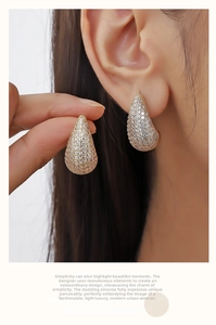 Detail of tear drop earrings with pave zircons and 18K gold plated finish